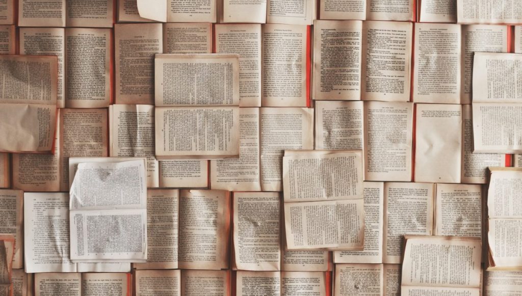 A collection of open books spread across a surface